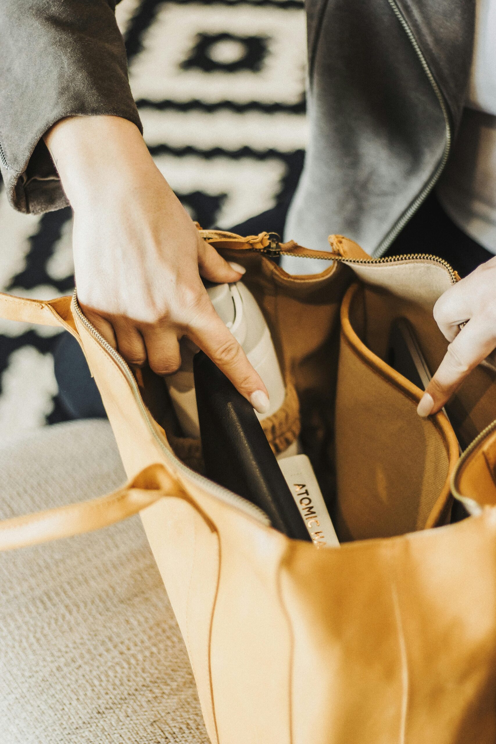 Une dame range sa bouteille d'eau dans son sac à main jaune moutarde. L'intérieur du sac est montré